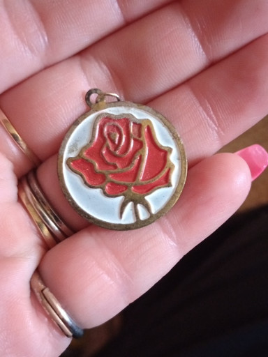 Enamel and gold-tone metal pendant featuring a red rose design