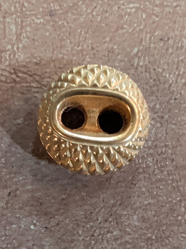 Gold-tone metal decorative button with textured oval design