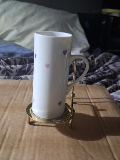 Porcelain mug with pink and purple heart pattern on brass stand
