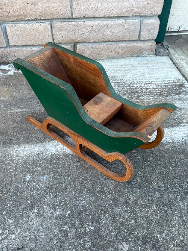 Vintage handcrafted wooden sleigh with green painted exterior