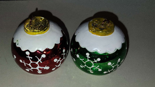 Pair of hand-painted glass or ceramic Christmas ornament-shaped salt and pepper shakers with molecular pattern design