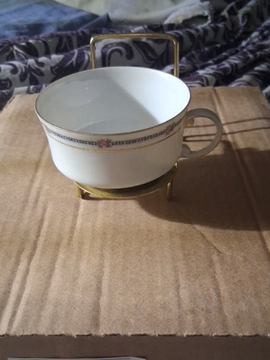 Porcelain bouillon cup with brass stand and handle, featuring floral decoration