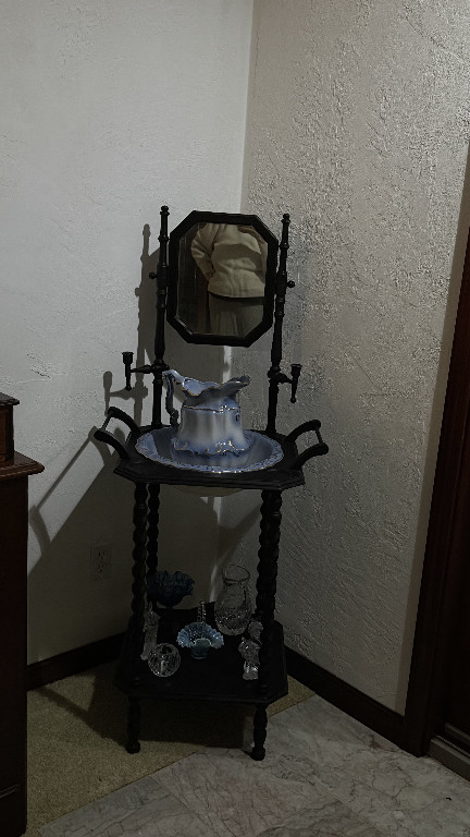 Victorian-era wooden washstand with ceramic pitcher and basin set