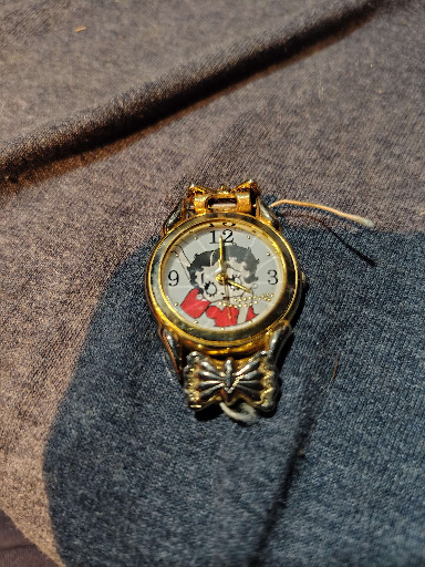 Gold-tone quartz wristwatch with novelty character dial and decorative bracelet band