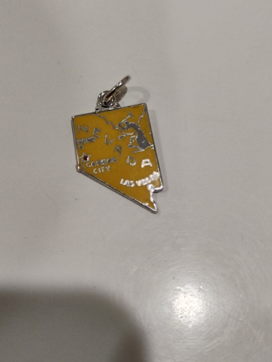 Sterling silver charm with yellow enamel depicting the state of Nevada