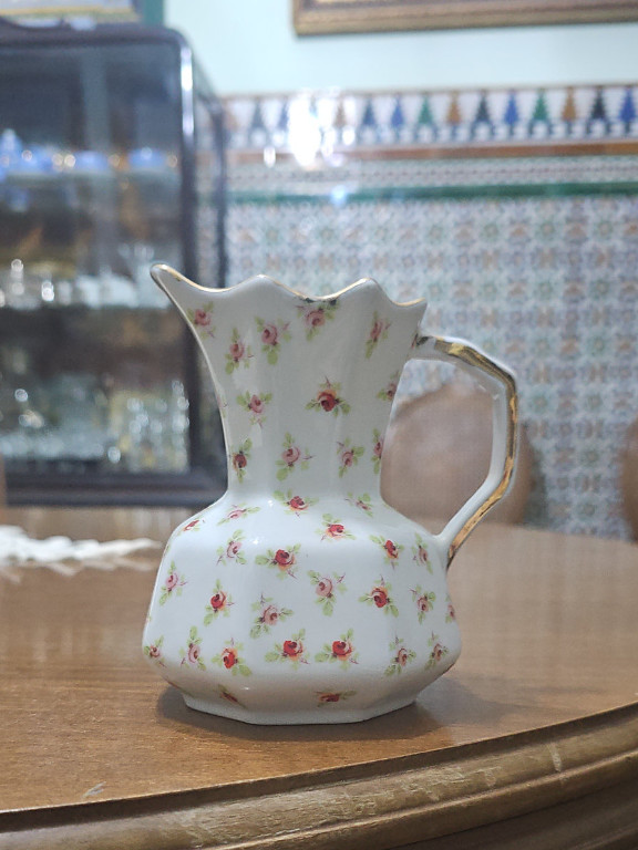 Jarra de porcelana con patrón floral de rosas pequeñas y asa dorada