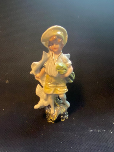 Porselein beeldje van een jongen met druiven en een hond