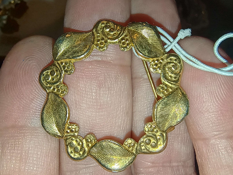 Gold-tone metal wreath brooch with leaf and scroll design