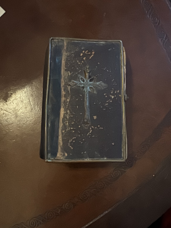 Antique leather-bound Catholic prayer book with embossed cross on cover