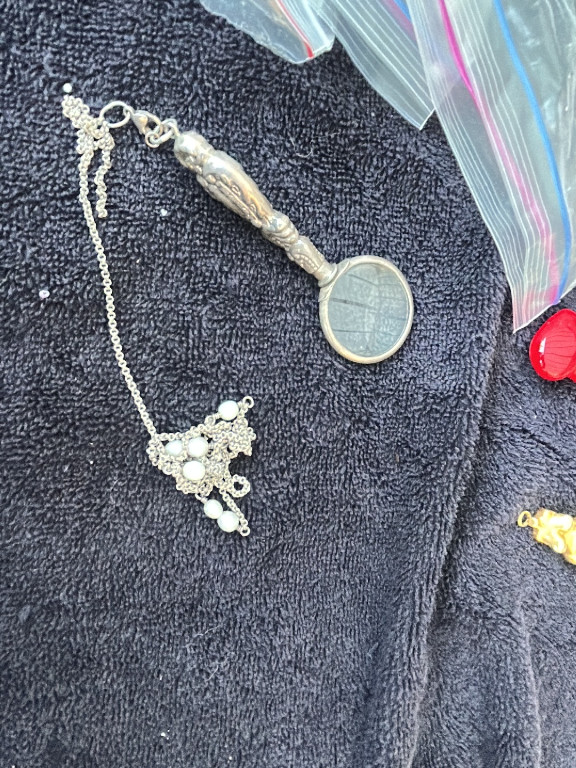 Silver-plated magnifying glass pendant with decorative handle on chain