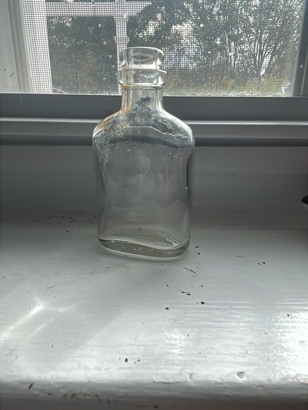 Clear glass bottle, likely a vintage utility or medicine bottle