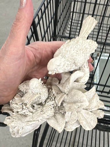 White ceramic or resin bird figurine on naturalistic branch base