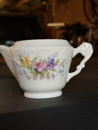 Porcelain creamer with floral decoration by W. S. George