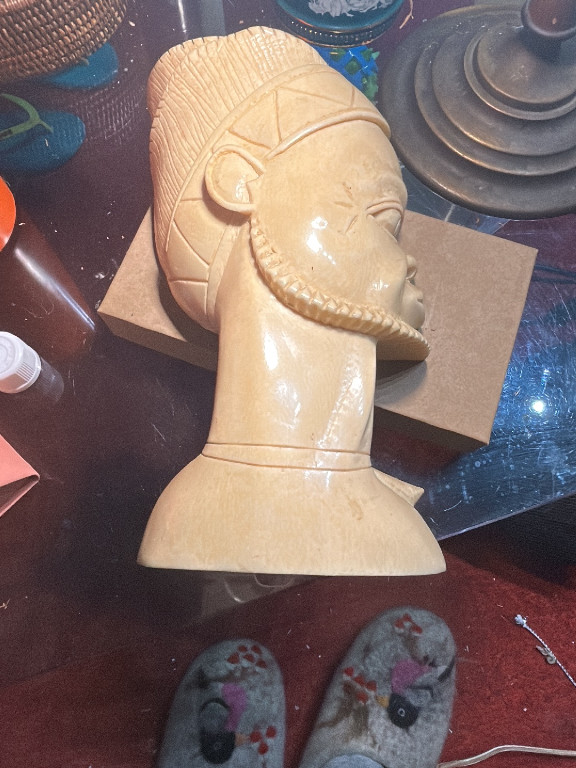 Scultura in avorio raffigurante testa di guerriero africano con acconciatura elaborata