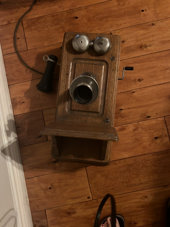 Oak wooden wall-mounted crank telephone from the early 1900s