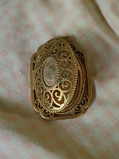 Gold-tone filigree locket pendant with faux gemstone center by Avon