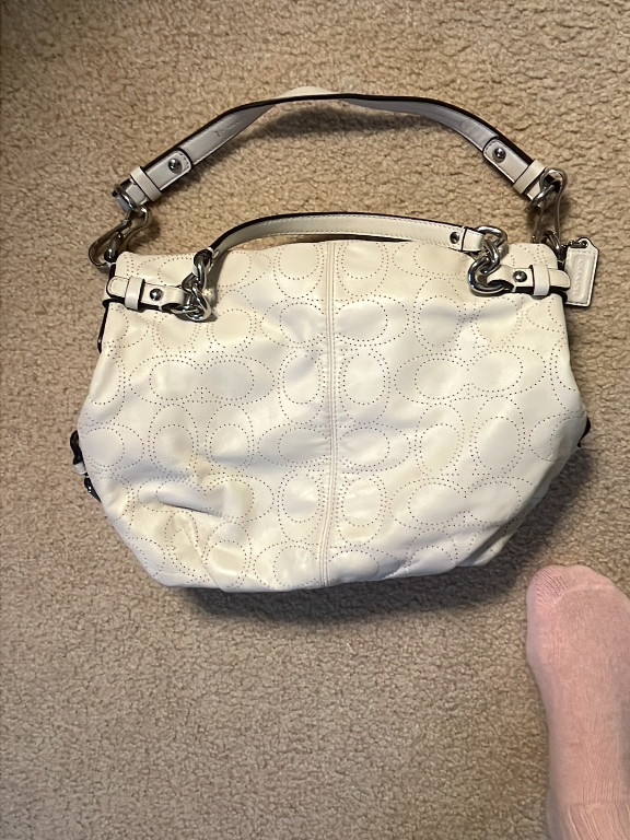 White leather handbag with perforated signature pattern by Coach
