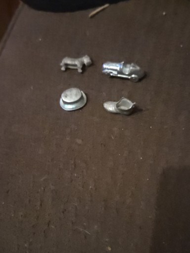 Metal Monopoly game tokens including race car, top hat, and other playing pieces