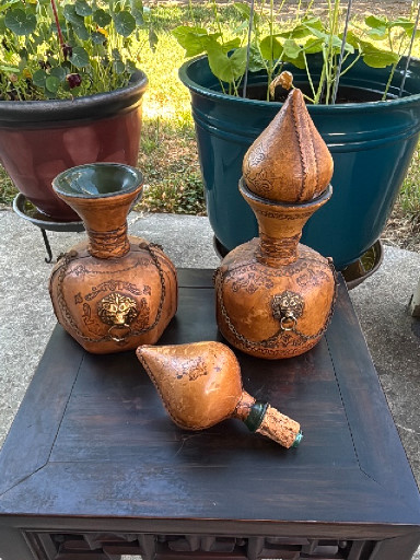 Set of two Italian leather-wrapped glass decanters with lion head medallions.
