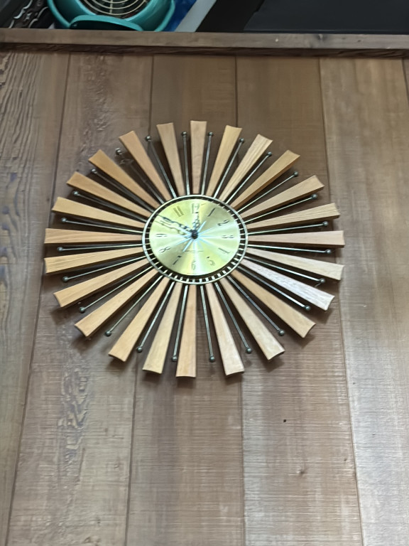 Mid-century modern sunburst wall clock with alternating wood and metal rays