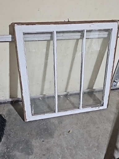 Vintage three-pane wooden window sash with wavy glass