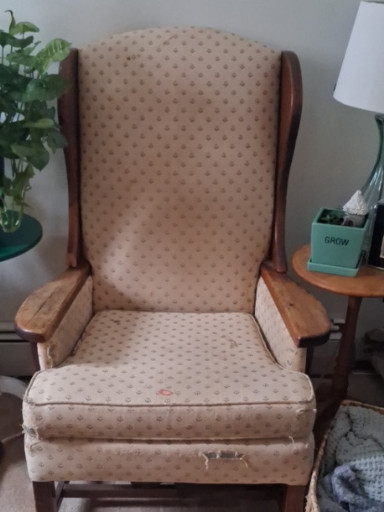 Upholstered wingback armchair with wooden frame and arms