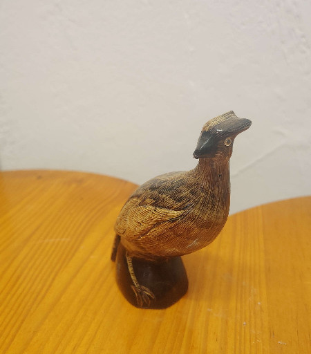 Hand-carved wooden bird figurine depicting a grouse or partridge