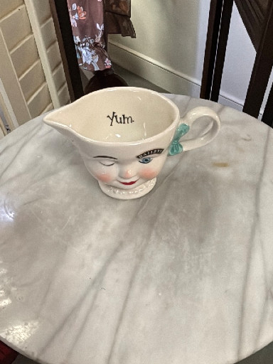 Ceramic creamer titled 'Yum' by Bailey's Irish Cream, featuring a winking lady's face with blue bow