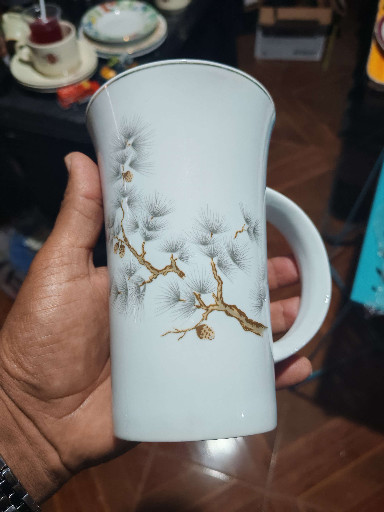 Taza de porcelana con diseño de pino y detalles dorados