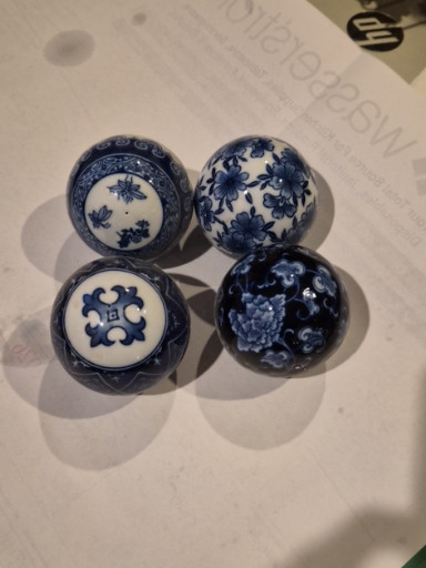 Set of four blue and white ceramic decorative orbs with traditional Chinese motifs