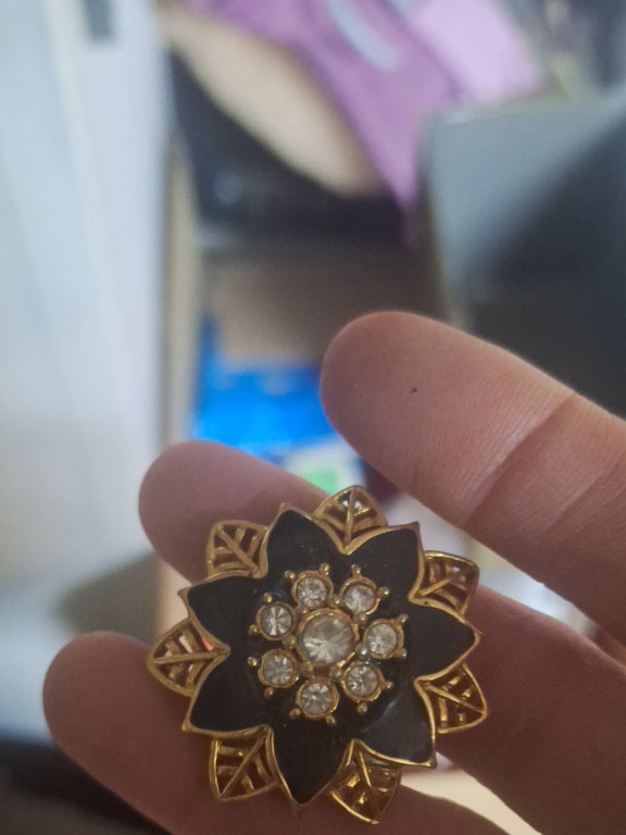 Gold-tone and black enamel flower brooch with rhinestone accents by Avon