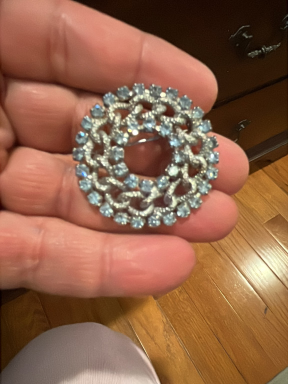 Silver-tone circular brooch with light blue rhinestones
