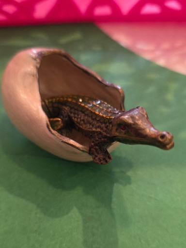 Resin sculpture of a crocodile hatching from an egg