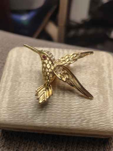 Gold-tone metal hummingbird brooch with crystal accents