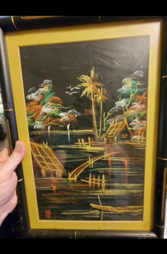 Vietnamese lacquer painting on wood depicting a village scene with boats and palm trees