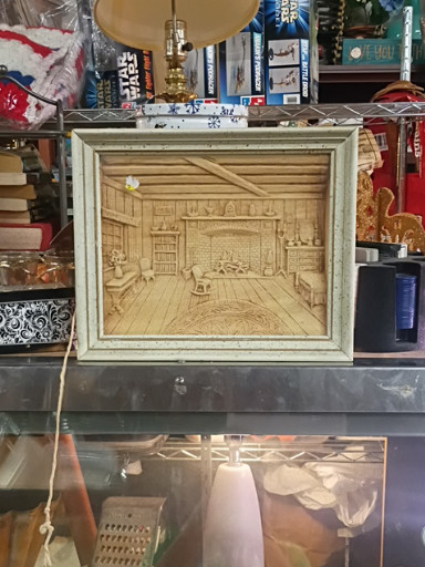 CNC-carved wood panel depicting a cozy cabin interior scene