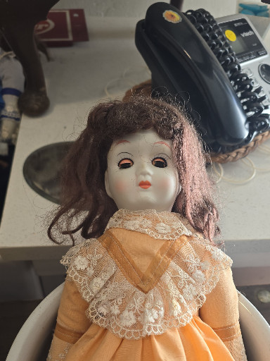 Porcelain doll with peach lace dress, likely by Schmid or similar manufacturer
