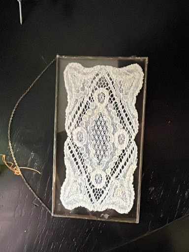 Handmade lace doily or table runner, likely bobbin lace or needle lace