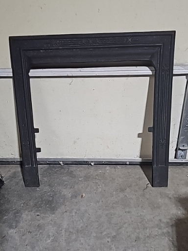 Cast iron fireplace surround with fluted columns and decorative molding, late 19th century Victorian era