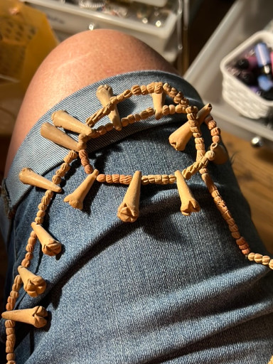 Wooden heishi bead necklace with carved trumpet-shaped fetishes, Native American style