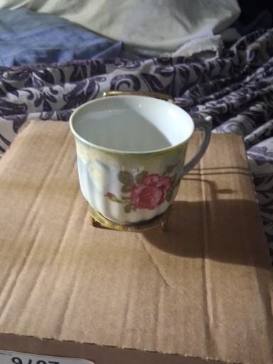 Porcelain teacup with pink rose decoration, likely German manufacture