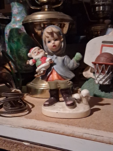 Ceramic figurine titled 'Christmas Girl with Santa Doll' by Napco