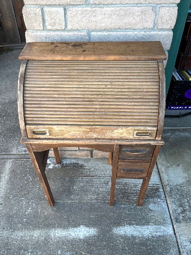 Oak child's roll-top desk with tambour door and double drawers. 24”w x 34”h x 15”d.