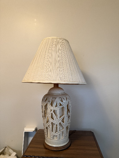 Ceramic table lamp with openwork leaf or lattice pattern and pleated fabric shade