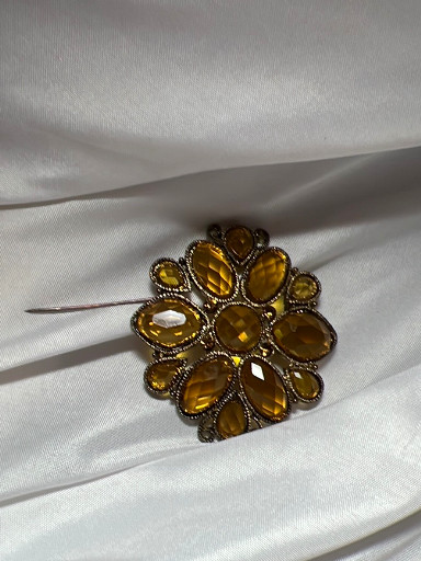 Vintage costume jewelry brooch with amber-colored glass stones in antiqued brass or bronze-tone metal setting