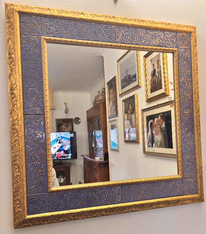 Specchio da parete con cornice dorata e pannello in maiolica a lustro blu