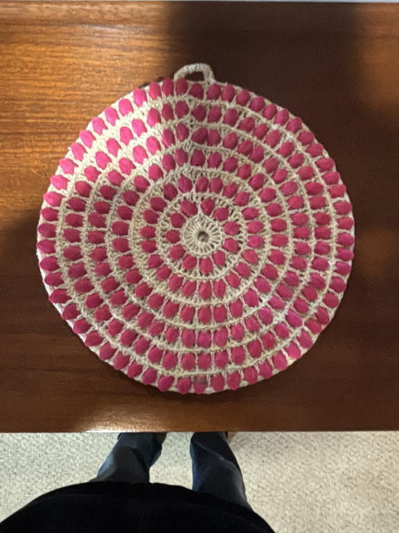 Hand-crocheted cotton hot pad or doily with pink and cream thread