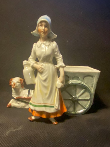 Porselein beeldje van een boerenvrouw met kar en koe