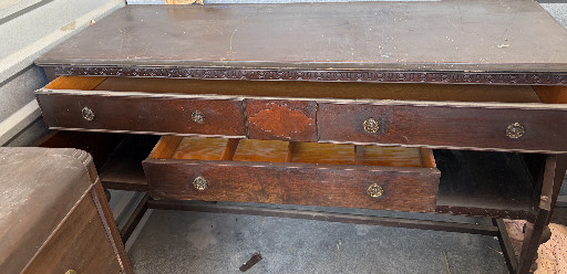 Oak dresser base with multiple drawers and decorative brass hardware