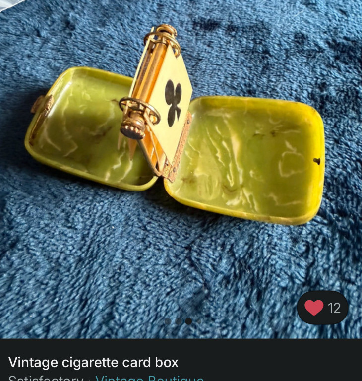 Yellow enamel cigarette card box with decorative metal clasp, circa 1920s